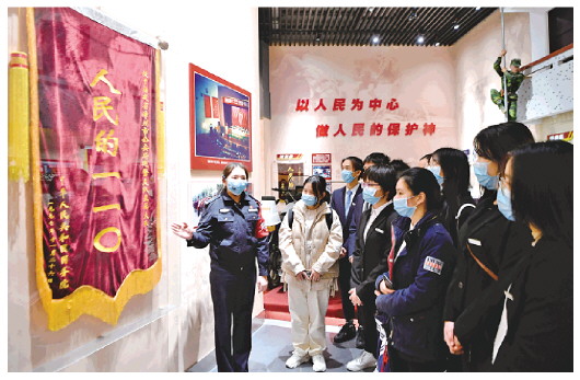 图为讲解员(左一)在"漳州110"事迹展览馆内向参观者介绍展品.